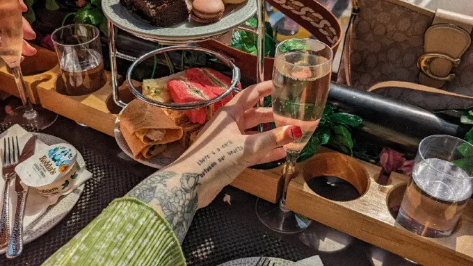 A hand holding a glass of prosecco.