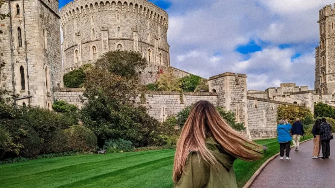A photo of a woman in front of Windsor Castle.